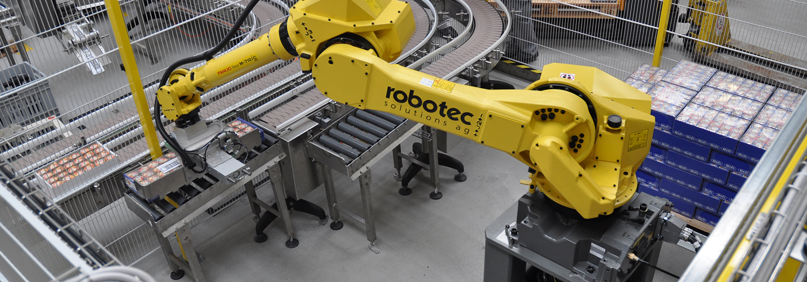 Robot M-710iC placing food carriers onto conveyor belt